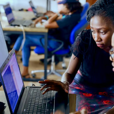 Two individuals looking at a laptop screen.
